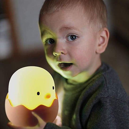 petit garcon tient veilleuse bebe poussin_coquille allumee