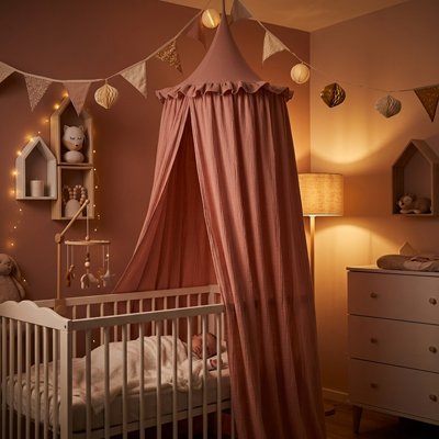 Ciel de lit rose installé chambre bebe dort