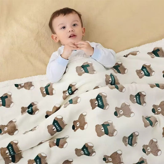 enfant couche avec couverture bebe polaire sur lui motif ours